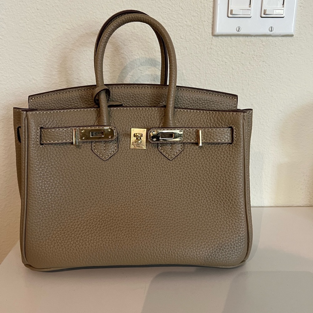 Gray Padlock handle bag with strap.